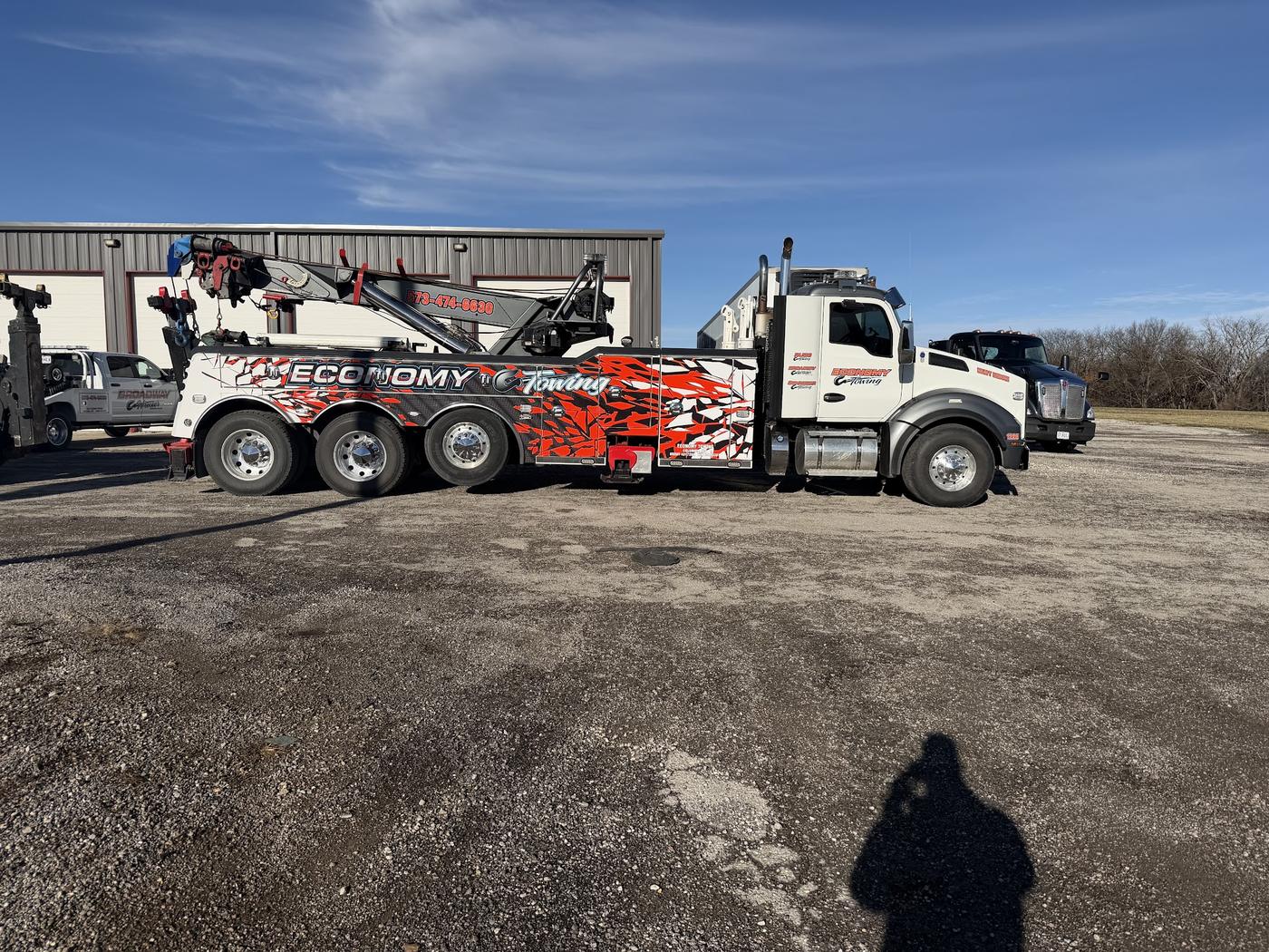 Side view of the Economy Towing Kenworth heavy wrecker outside the shop